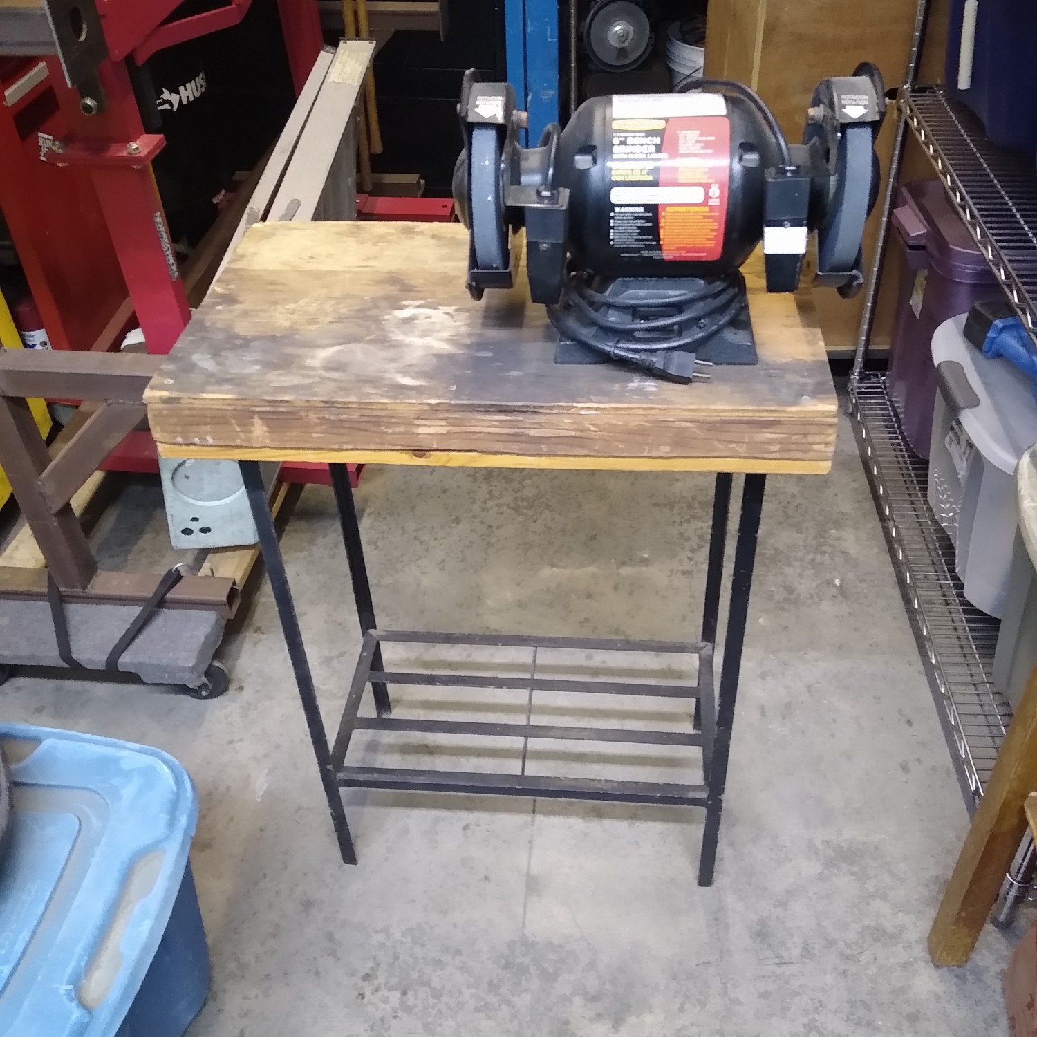 Bench grinder mounted on small table.